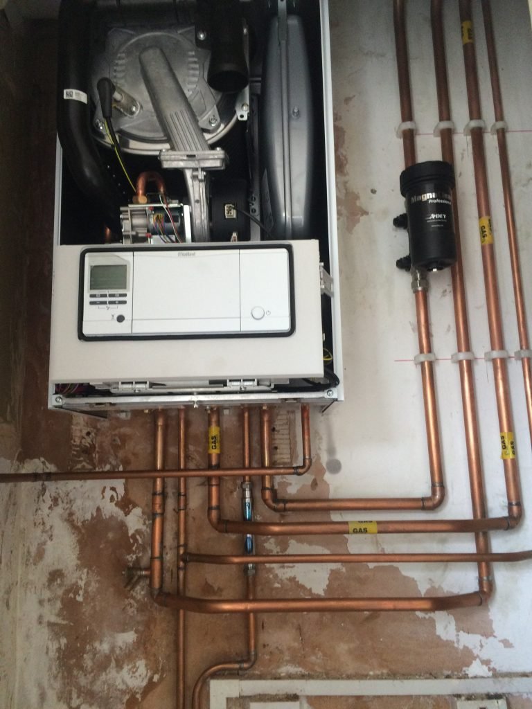 Open combi boiler with copper pipework during a boiler repair